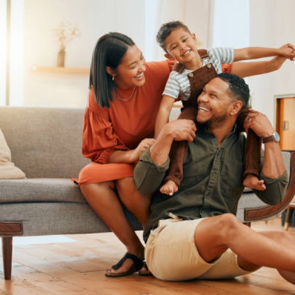 A happy mixed race family of three relaxing in the lounge and being playful together. Loving black family bonding with their son while playing fun games on the sofa at home